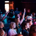 A vibrant youth group engaged in worship during a church service in Elk Grove.